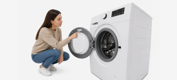 Frau sucht das Typenschild an einer Waschmaschine