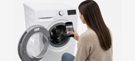 Frau scannt das Typenschild einer Waschmaschine mit ihrem Smartphone